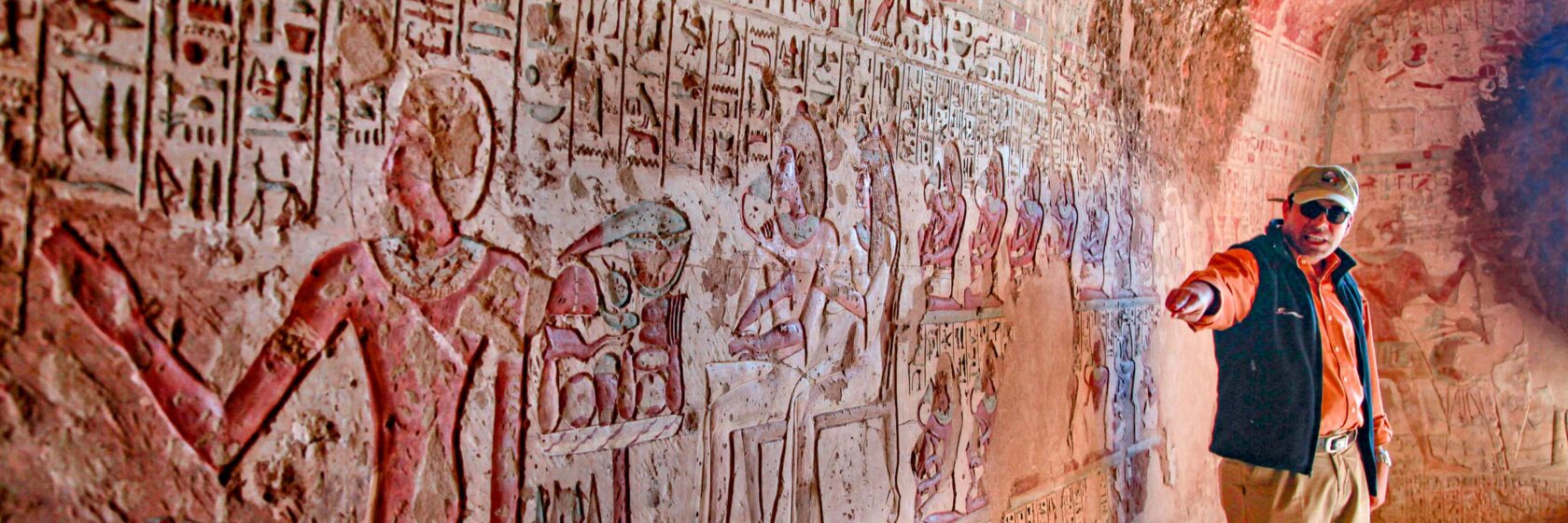 A trip leader showing a mural in Egypt.