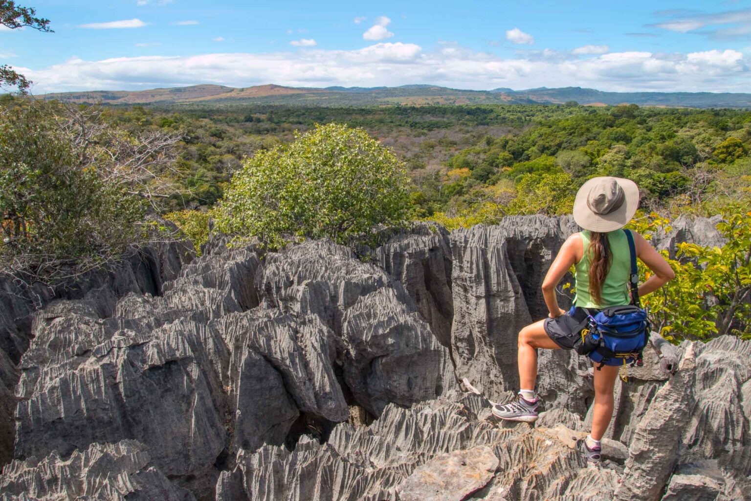 Hiker looks out over Madagascar’s tsingy limestone pinnacle rock formations.