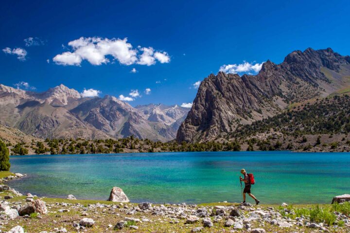 A hiker passing by a lake in Tajikistan.