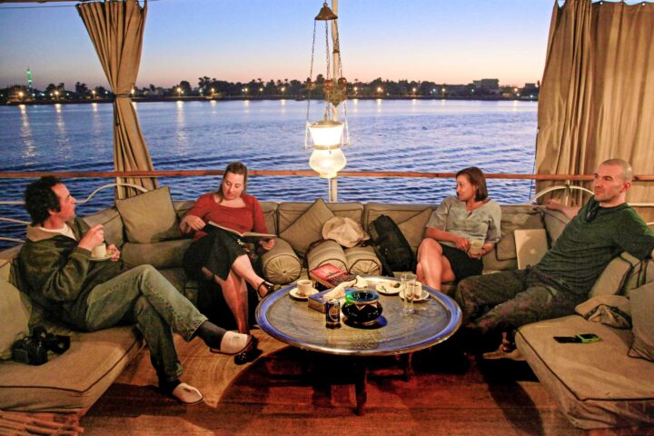 Four tourists relaxing in a waterfront lounge in Egypt.