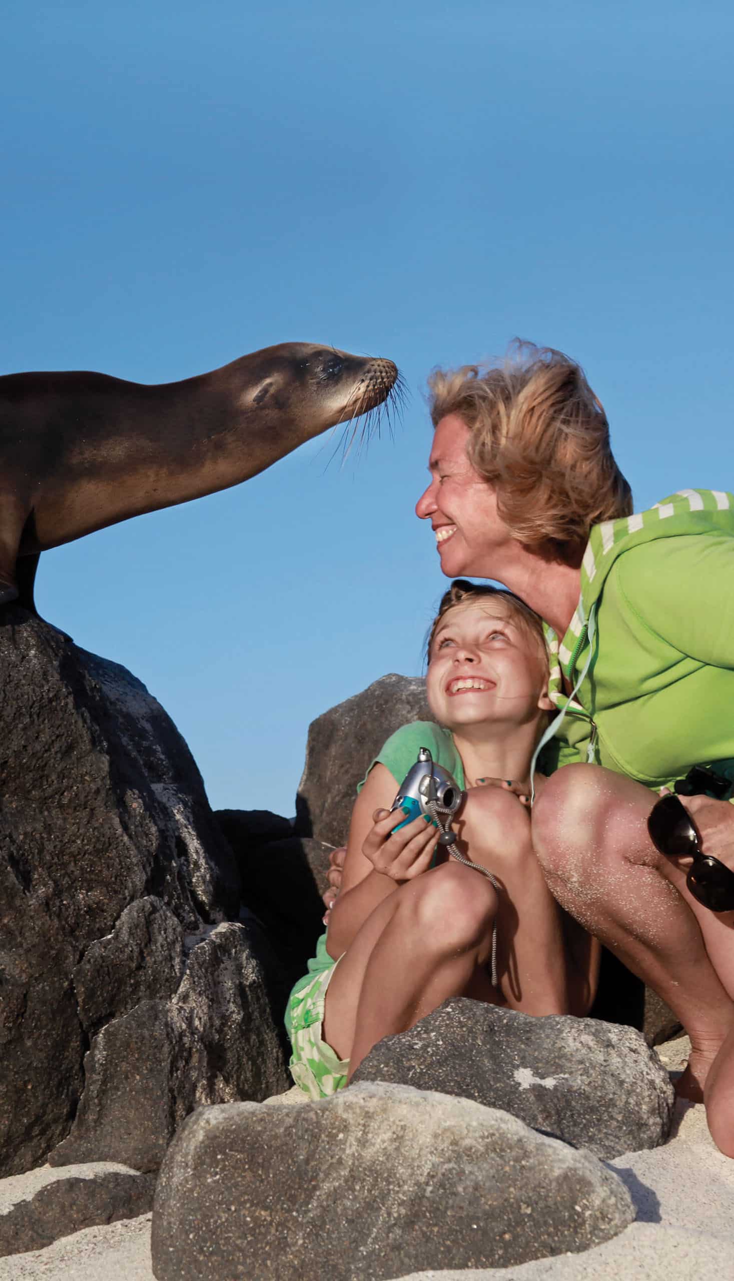 A mother and daughter interacting with a sea lion.