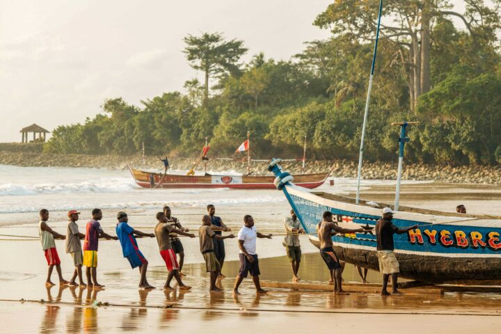 A group of men pulling a boat in Ghana.