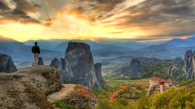 A hiker overlooking a landscape in Greece.