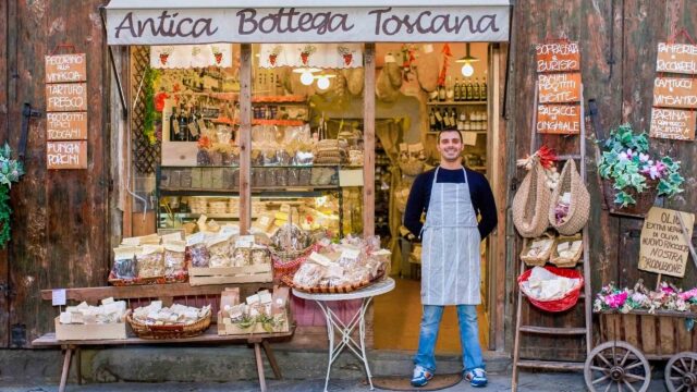 A man standing in front of a storefront in Italy.