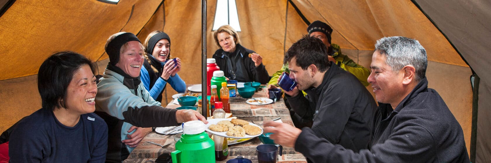 A group of travelers in Kilimanjaro enjoying a meal together.