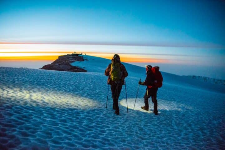 Two travelers hiking up a. summit in Kilimanjaro.
