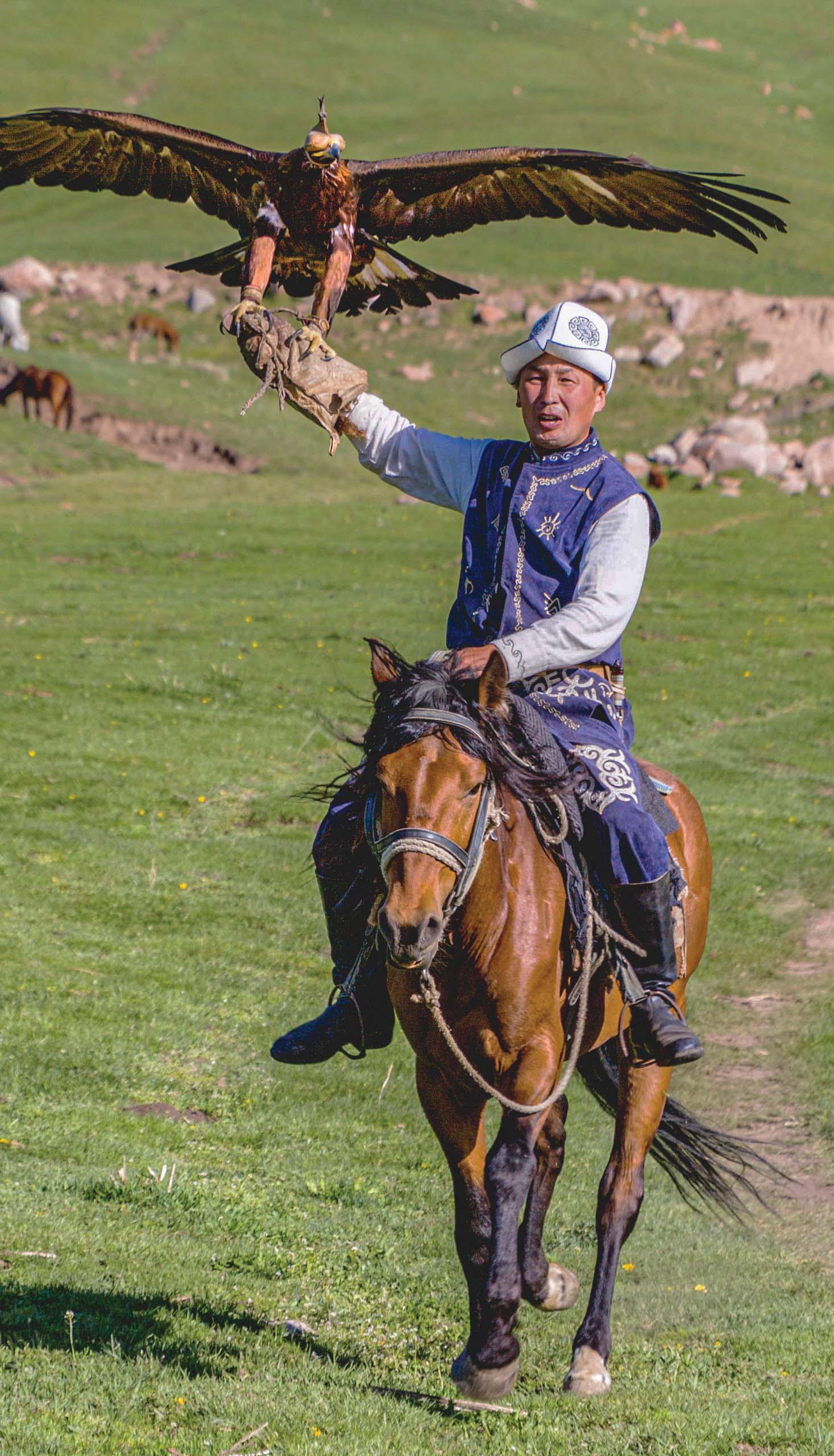 Eagle Hunter holds his eagles on horseback, ready to take flight in Kyrgyzstan.