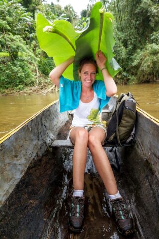 A tourist on a trip in a traditional boat on a river in Masoala national park, Madagascar.