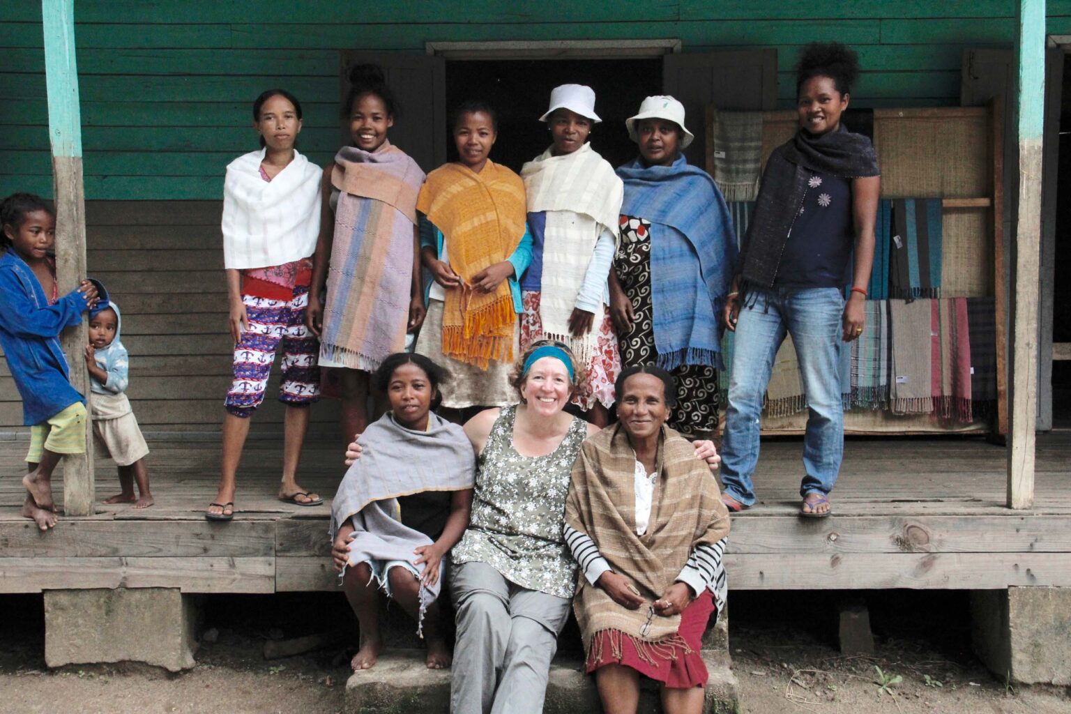 Tourist in Madagascar with local weavers showing handicrafts.