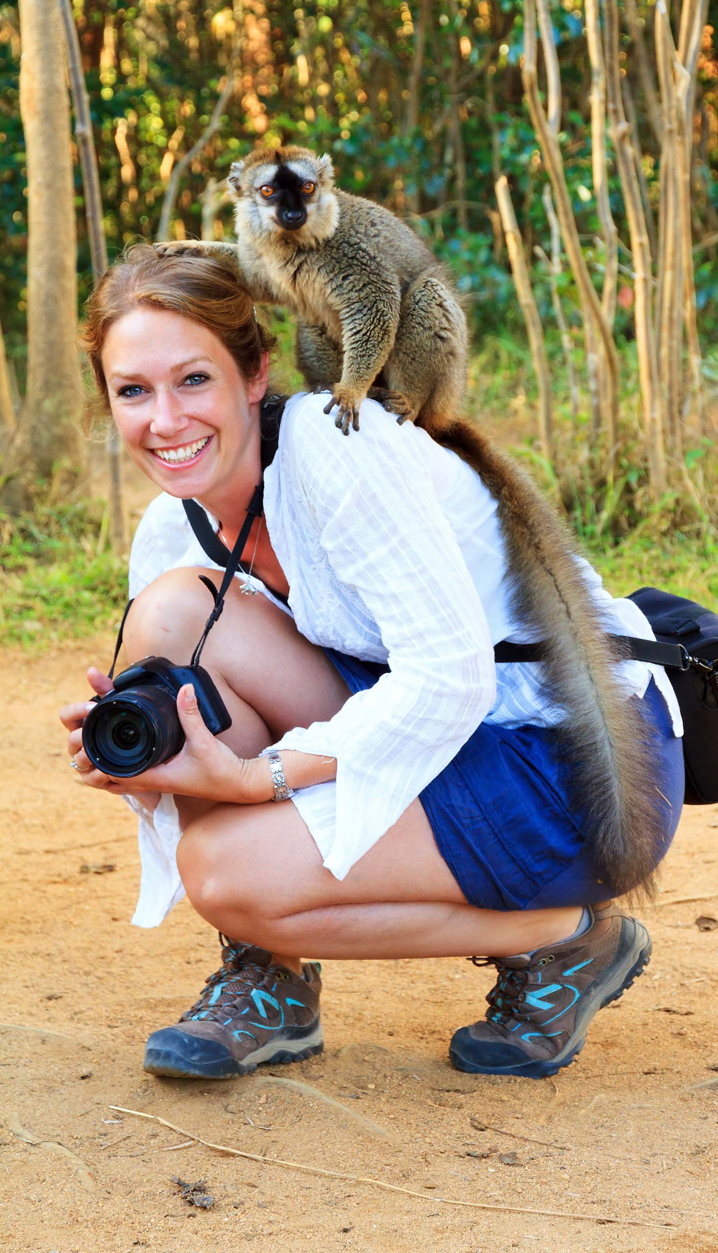 A wild monkey on a wildlife photographer's shoulder.