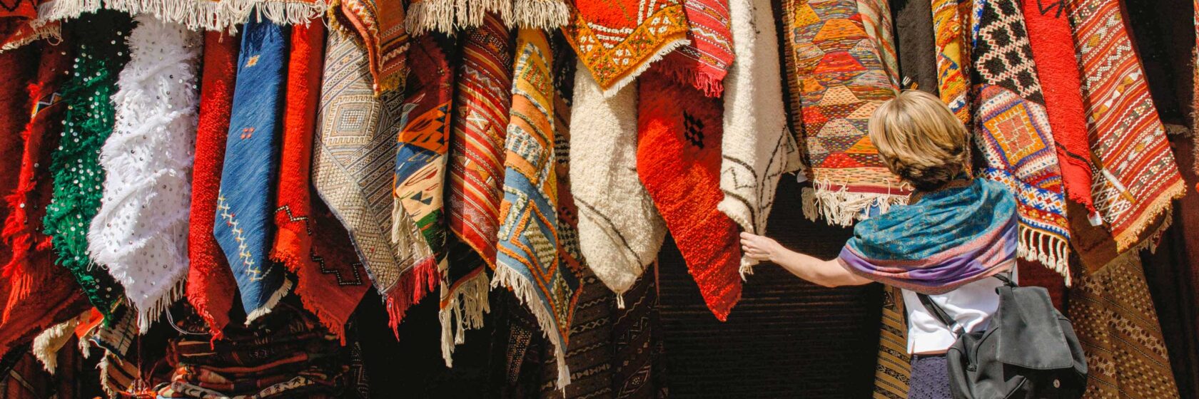 A woman shopping for rugs in Marrakech.