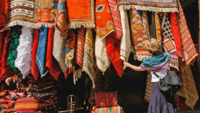 Woman shopping for carpets rugs in a market in Marrakech.