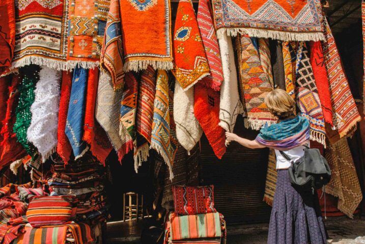 Woman shopping for carpets rugs in a market in Marrakech.