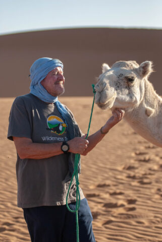 A man alongside a camel.