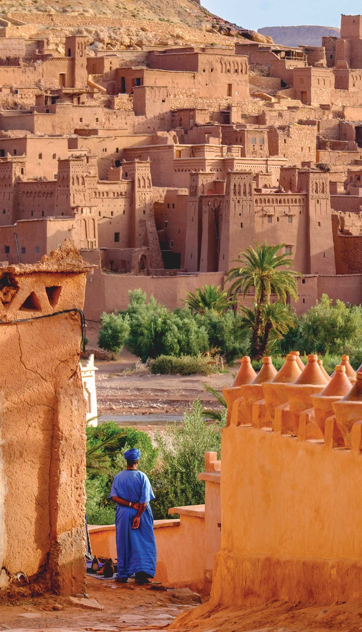 A local inhabitant of Ait Ben Haddou contemplating the old city (ksar) lightened by morning light.