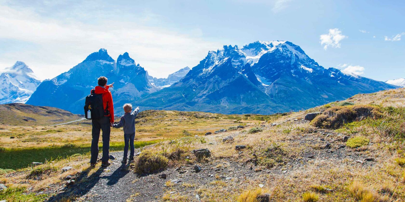 A parent and their child looking at mountains in Patagonia.