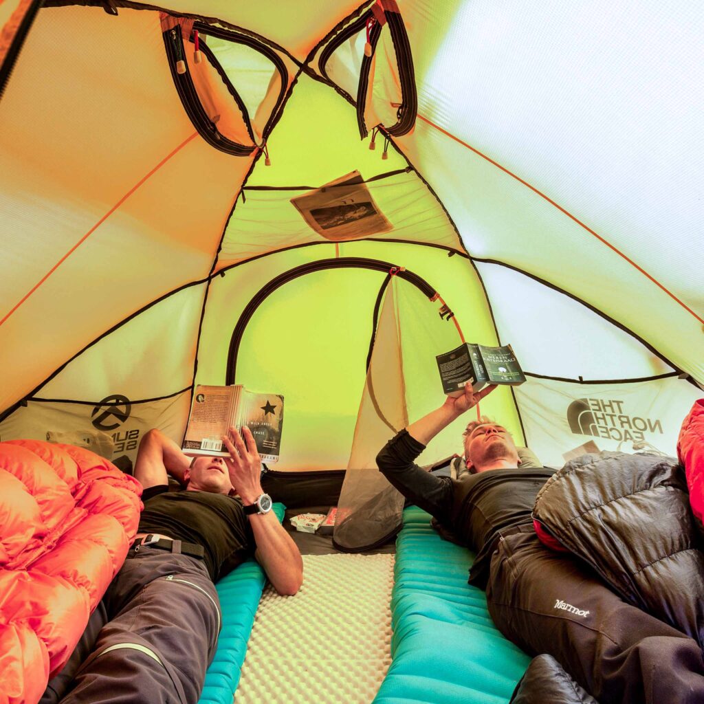 Two travelers resting in a tent.