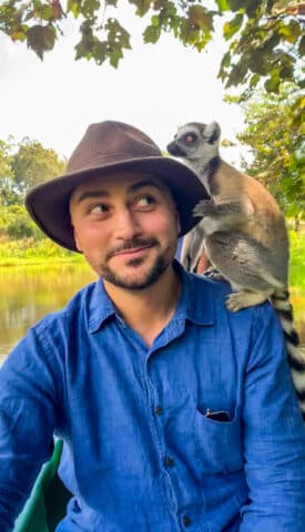 A lemur on a man's shoulder.