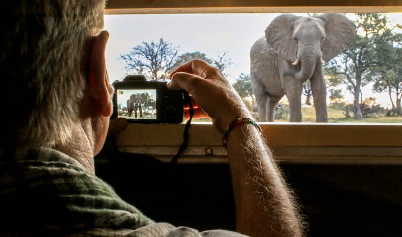 A photographer taking photos of an Elephant.
