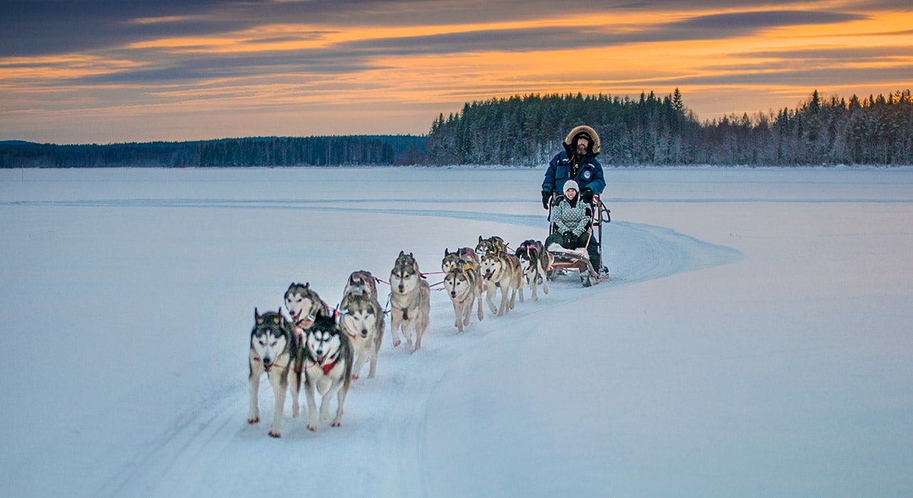 https://www.wildernesstravel.com/wp-content/uploads/2023/06/22-CHURCHPO-canada-winter-manitoba-dog-sled-sunset-travelers.jpg