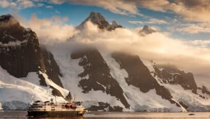 An expedition ship cruises along the Lemaire Channel, Antarctica.