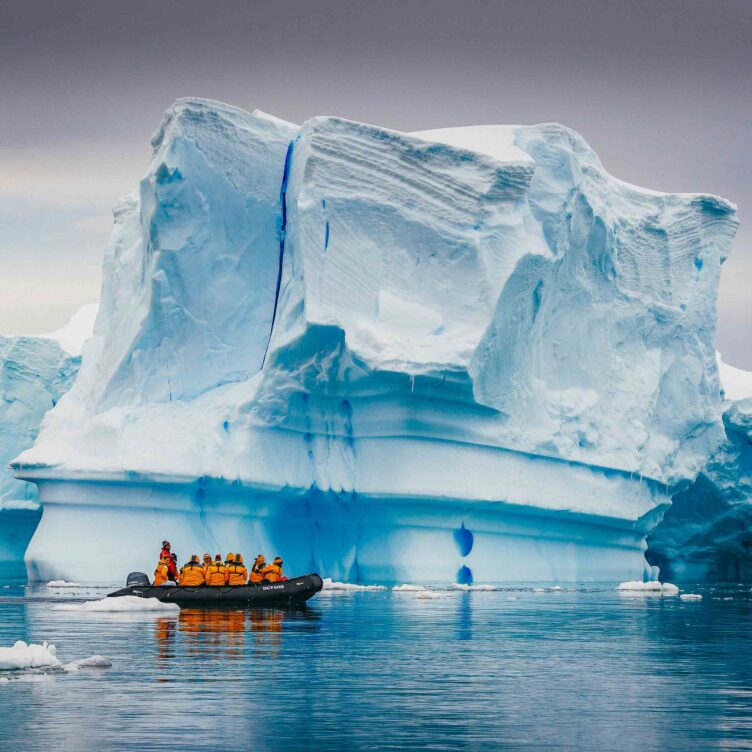 Tourists on a boat in Antarctica near icebergs.