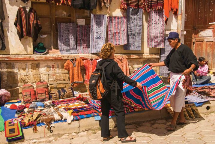 A women looking at rugs at a Sunday market in Bolivia.