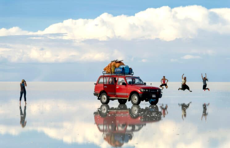 Tourists and a red car at Salar de Uyuni.