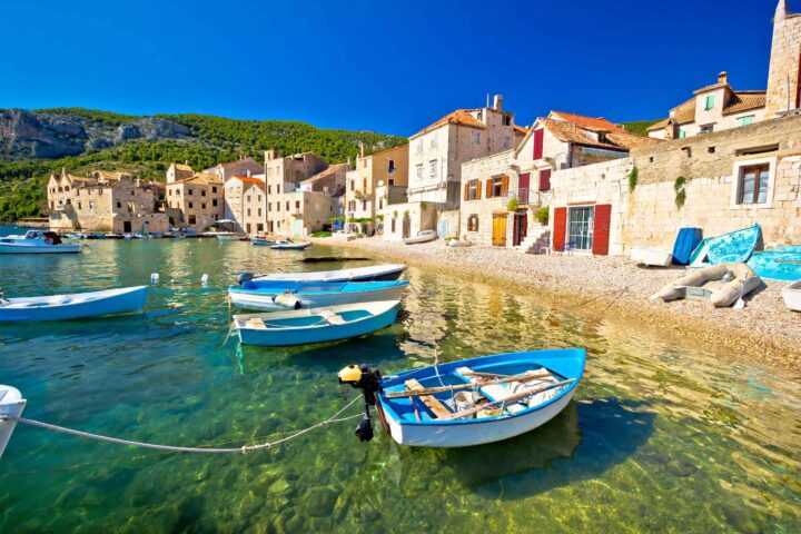 A beach in Croatia with blue boats.