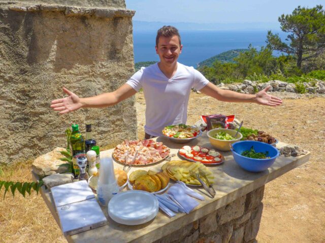 A man posing with a lunch buffet in Croatia.