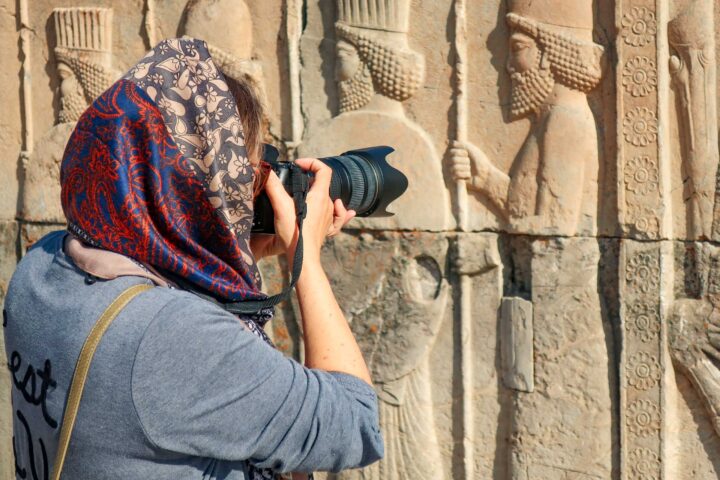 A photographer taking photos of ancient engravings in Iran.