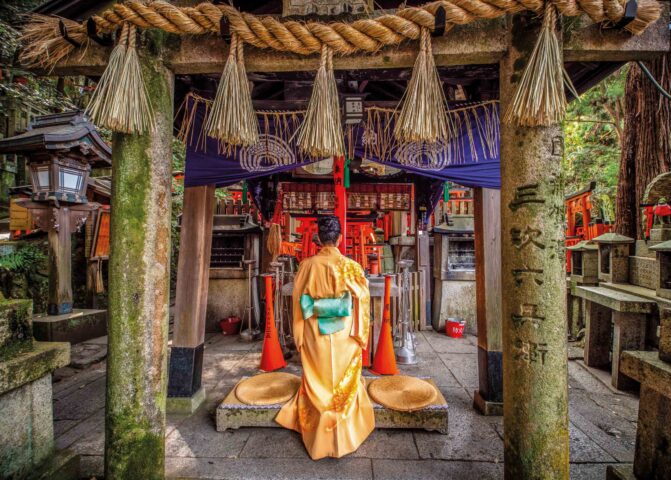 A woman praying at Fushimi Inari Taisha temple.