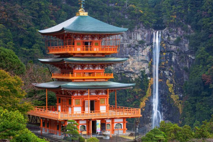 A three story pagoda with Nachi Falls in the background.