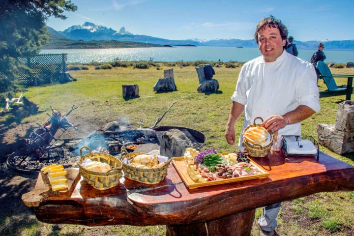 A chef setting up appetizers outdoors.