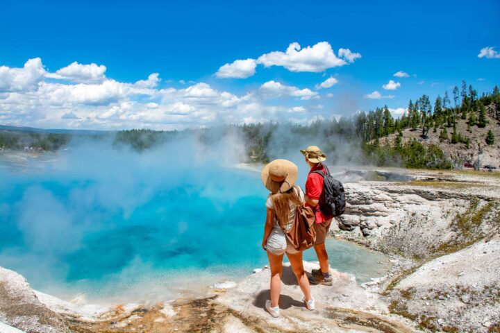 A couple observing Excelsior geyser at Yellowstone national park.
