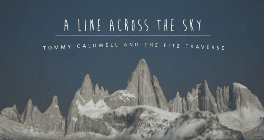Snow-covered mountain peaks under a deep blue sky with the text "A Line Across The Sky: Tommy Caldwell and the Fitz Traverse" displayed above the peaks, capturing an epic Adventure that could inspire short films.
