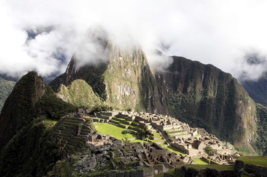 A mist-covered mountain watches over the ancient ruins of Machu Picchu, its stone steps and terraces emerging from the lush greenery like a testament to bygone leaders.