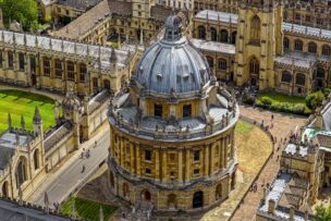 Aerial view of the Radcliffe Camera, a circular stone library with a domed roof, surrounded by historic university buildings and walkways in Oxford—an iconic stop for those exploring England travel beyond London attractions.
